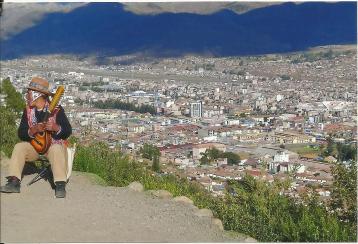 City overview with guy playing little guitar in Cusco