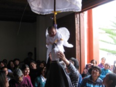 Some church goers were more interested in fixing a statues head-dress more then the baby swinging behind them.